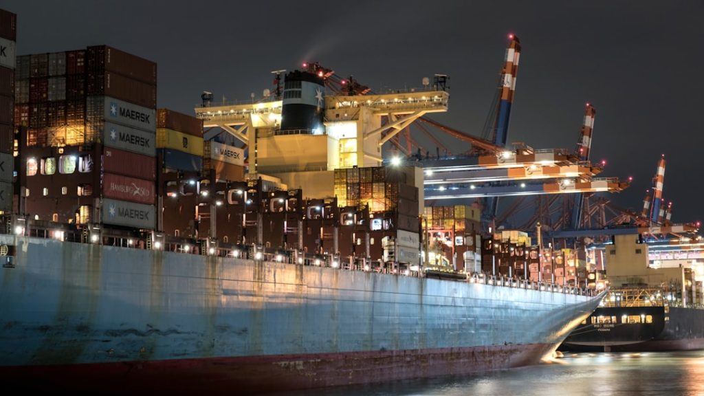 a-large-cargo-ship-in-a-harbor-at-night-afhlylbtnfq